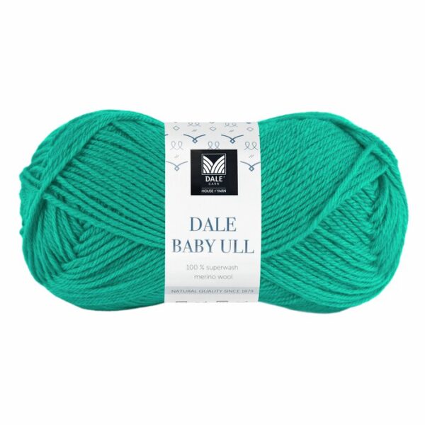 Et nøste med Dale Baby Ull-garn i fyldig Tropisk blå, laget av 100 % superwash merinoull, er elegant pakket inn med en hvit etikett som viser merke- og produktdetaljer.
