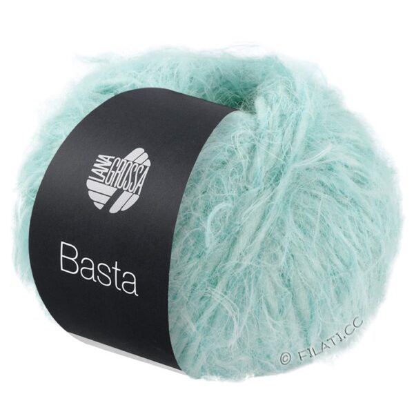 Et nøste av lyseblått fluffy garn merket "Lana Grossa Basta" i nyanse 17 Sart blå, med et svart og hvitt bånd rundt midten.