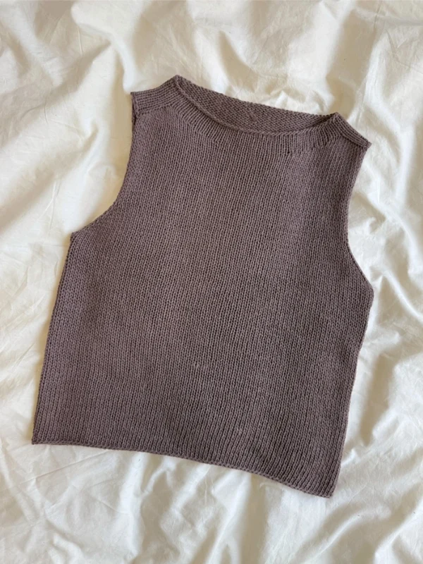 Ivy Top, en ermeløs, brun strikk, er lagt flatt på en hvit stoffbakgrunn.