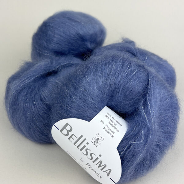 Et nøste av Bellissima by Permin mohairgarn i Chambrayblå (883070) hviler på en lys flate, med en merkelapp som viser fiberinnhold og merkeinformasjon.